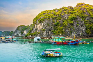 Boat at floating village of fishers and fish or oyster farmers in Halong Bay Vietnam