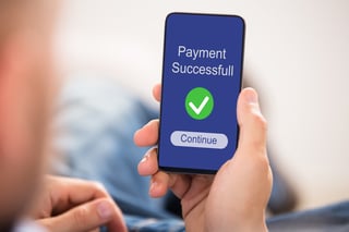Close up of a person's hand showing payment successful message Close up of a person's hand showing payment successful message