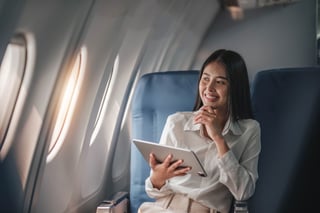 Asian Young Woman Using Tablet Sitting Near Windows At First Class Asian Young Woman Using Tablet Sitting Near Windows At First Class