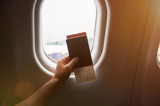 Hand Holding Passport With Airplane Ticket On Plane Window Hand Holding Passport With Airplane Ticket On Plane Window