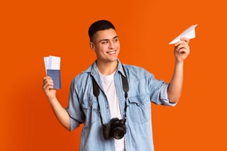 Traveler With Camera Holding Passport Flight Tickets And Paper Airplane Traveler With Camera Holding Passport Flight Tickets And Paper Airplane