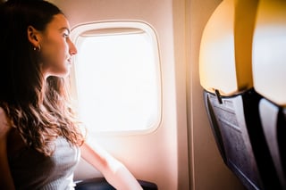Young Girl Looking Through The Window While Traveling On Airplane Young Girl Looking Through The Window While Traveling On Airplane