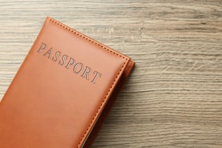 Brown passport cover on wooden table Brown passport cover on wooden table