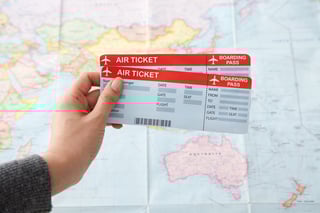 Hand holding air tickets over map Hand holding air tickets over map