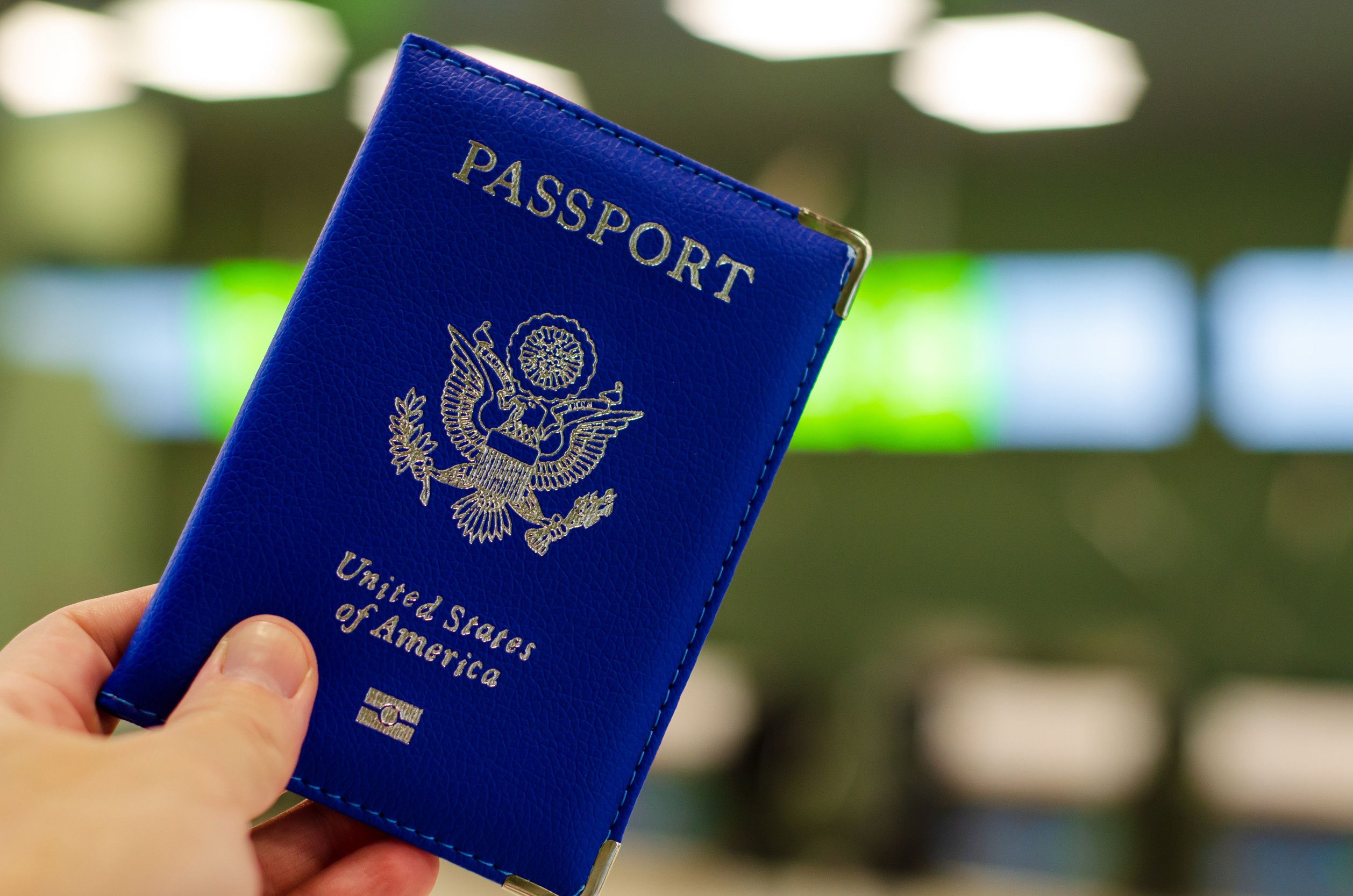Hand holding U.S. passport in the airport Hand holding U.S. passport in the airport