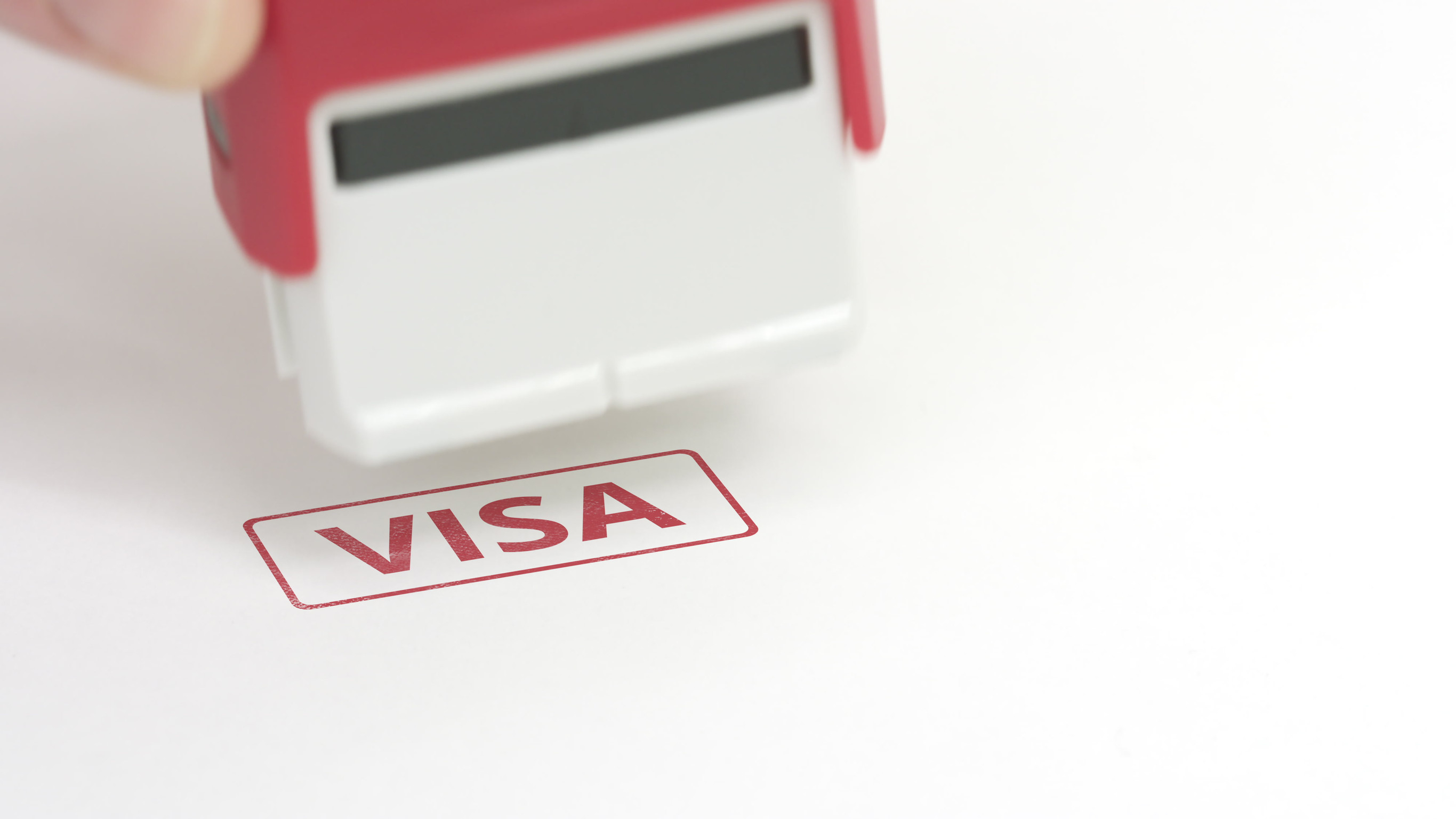 Putting red visa rubber stamp on the paper close up shot Putting red visa rubber stamp on the paper close up shot