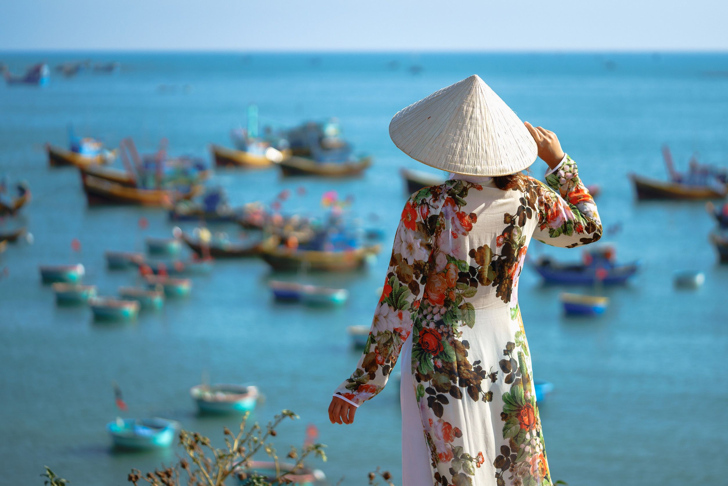 Back of male tourist traveler in Vietnamese hat on a bridge in old town in Hoi An in Vietnam in Asia Back of male tourist traveler in Vietnamese hat on a bridge in old town in Hoi An in Vietnam in Asia